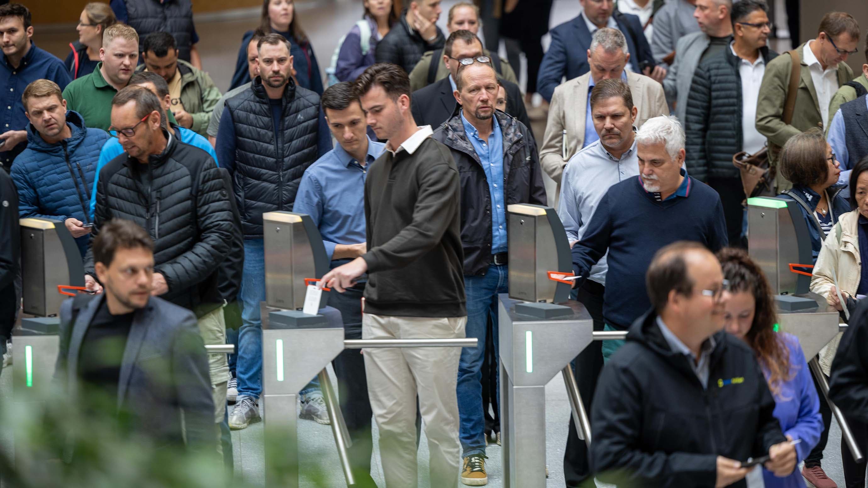 Visitors enter the trade fair through the turnstiles at the entrance