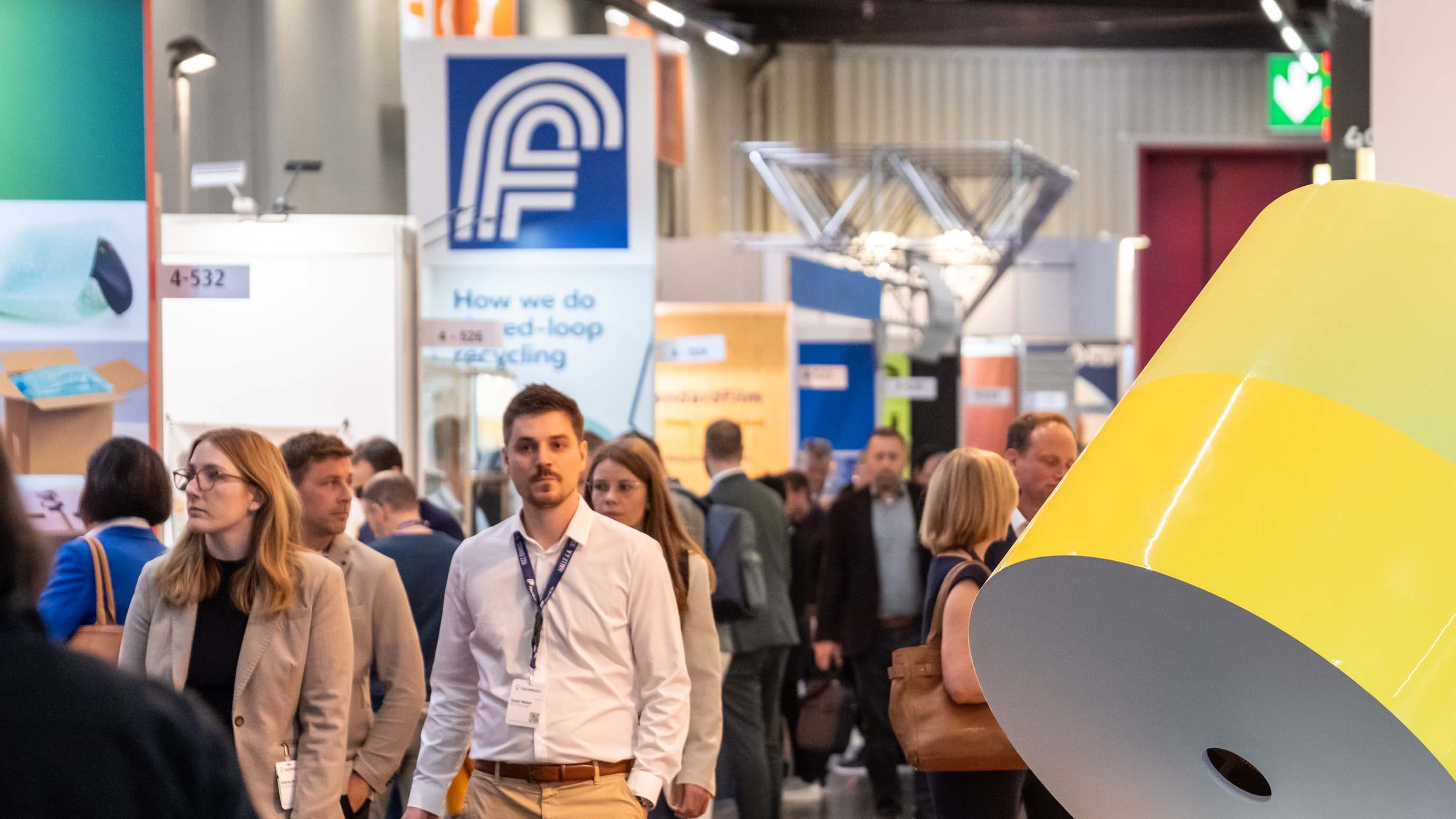 Visitors walk across the trade fair, past stands and exhibits